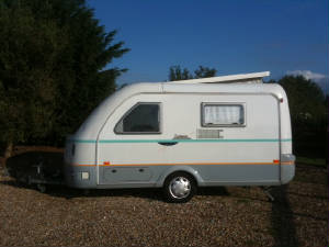 A small touring caravan on a gravel hardstanding