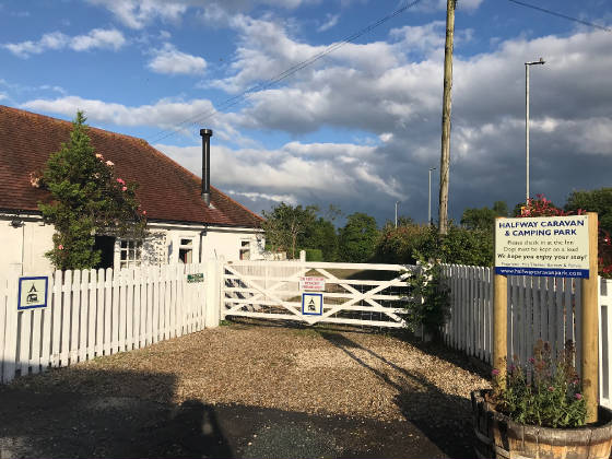 The white gate into the park beside the cottage, with the park sign on the right